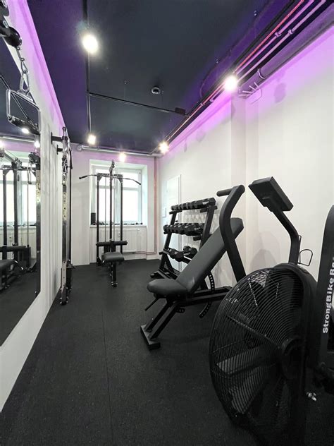 Interiér Legends Gym s retro dizajnom a profesionálnymi posilňovacími strojmi.