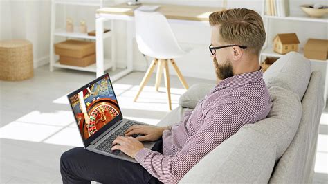 Ilustračná fotografia muža pracujúceho za počítačom, ktorý sa usmieva.