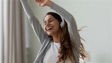 Žena cvičiaca s úsmevom pri počúvaní hudby.