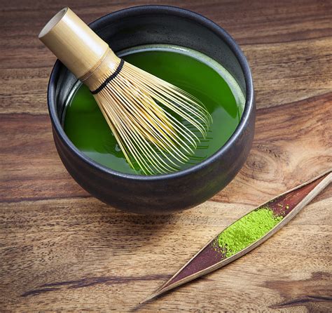 Fotografia misky s matcha čajom a bambusovou metličkou