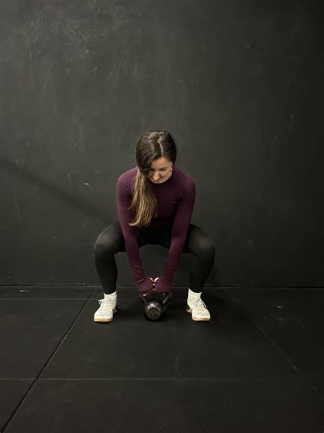 žena vykonávajúca cvik s kettlebellom v tvare osmičky