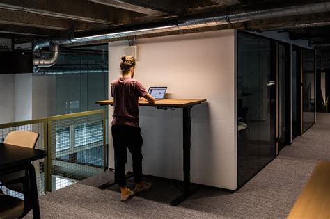 Osoba pracujúca pri výškovo nastaviteľnom stole.