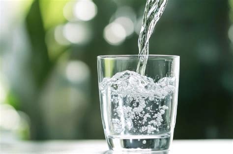 Nádoba s vodou a pohár, symbolizujúce dostatočný pitný režim.