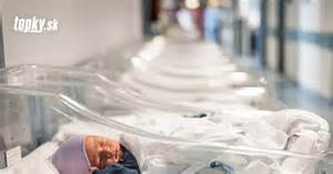 žena držiac novorodenca a usmievajúca sa