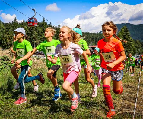 skupina usmievavých bežcov pretekajúcich v parku