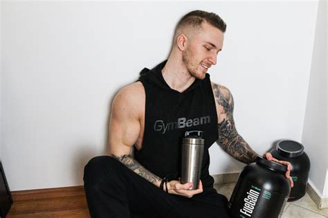 Športovec pripravujúci si proteínový nápoj po intenzívnom silovom tréningu