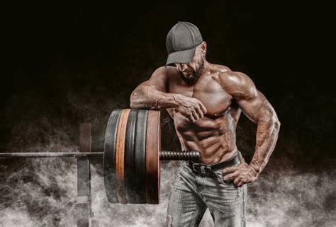Muž dvíhajúci činky vo fitness centre