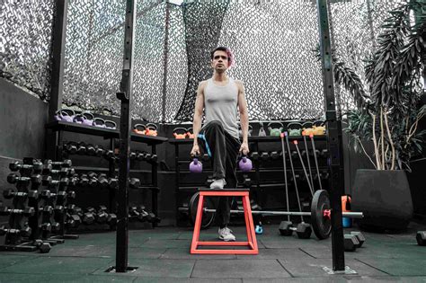 Muž po päťdesiatke cvičí so závažím vo fitness centre