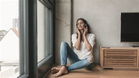 Zmätená žena sediaca osamote pri okne po rozchode, zamyslená