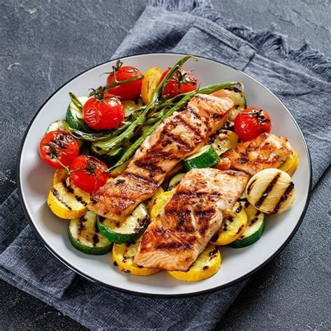 Ukážka keto taniera s grilovanou rybou, čerstvou zeleninou a avokádom.