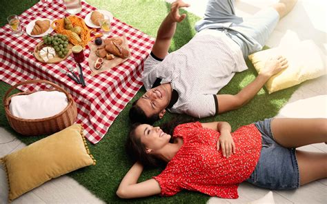 Šťastný pár si užíva piknik v prírode s košíkom plným zdravých jedál.